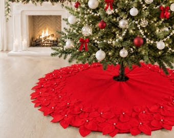 Peut inclure: Une jupe de sapin de Noël circulaire rouge ornée d'une bordure décorative composée de pétales de poinsettia en feutrine superposés. Chaque fleur en tissu est agrémentée d'une petite perle blanche au centre et d'une ouverture centrale.