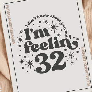 May include: A white tablet screen displaying a black and white graphic design with the text "I don't know about you but I'm feelin' 32" surrounded by stars. The graphic design is on a white background.