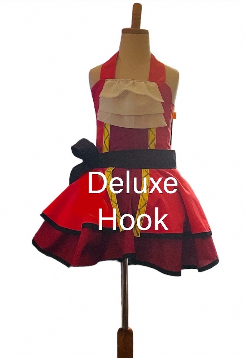 May include: A red and black apron with a white ruffle and gold trim. The apron has a black bow and the text "Deluxe Hook" is printed on the front.