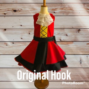 May include: A red and black dress with a white ruffle collar and a yellow and black design on the bodice. The dress has a black belt and a black and red skirt. The dress is on a wooden mannequin. The text "Original Hook" is at the bottom of the image.