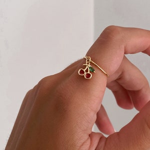 Anello regolabile in oro con pietra preziosa a forma di ciliegia.