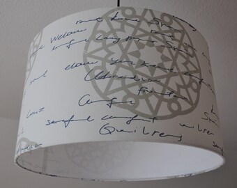 May include: A white lampshade with a geometric pattern in gray and blue script writing. The writing includes the words "soul", "love", "comfort", and "Guillery".