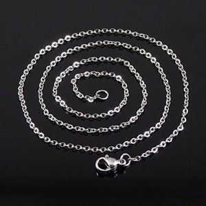 May include: A silver chain necklace with a lobster clasp closure. The chain is made of small, oval-shaped links.