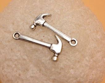 May include: Two silver-toned hammer charms with a loop for attaching to a necklace or bracelet.