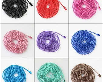 May include: Nine coiled ball chains in a range of colours: black, red, pink, purple, blue, turquoise, and bronze. Each chain is neatly arranged in a circular pattern, highlighting the metallic sheen of the beads and the matching clasp.