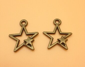 Peut inclure: Deux breloques en métal en forme d'étoile de couleur or antique avec une petite étoile à l'intérieur de la grande étoile. Les breloques ont une boucle en haut pour les attacher à des bijoux ou d'autres objets artisanaux.