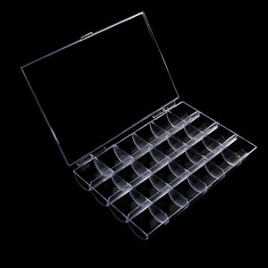 May include: A clear plastic storage box with a hinged lid and 24 individual compartments. The box is empty and ready to be filled with small items.