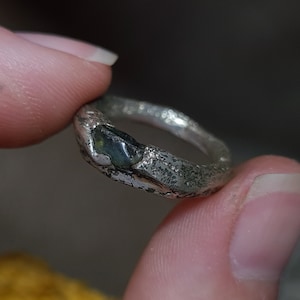 以下が含まれることがあります： テクスチャ加工されたバンドにダークグリーンの宝石がセットされたシルバーリング