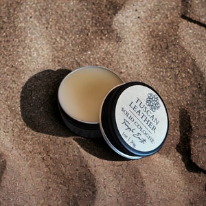 Pu&ograve; includere: Una piccola latta di colonia solida al profumo di cuoio toscano. La latta &egrave; nera con un'etichetta bianca che recita "Tuscan Leather Solid Cologne" e "Teph's Scents" con un disegno floreale. La latta &egrave; da 1 oz / 34g.