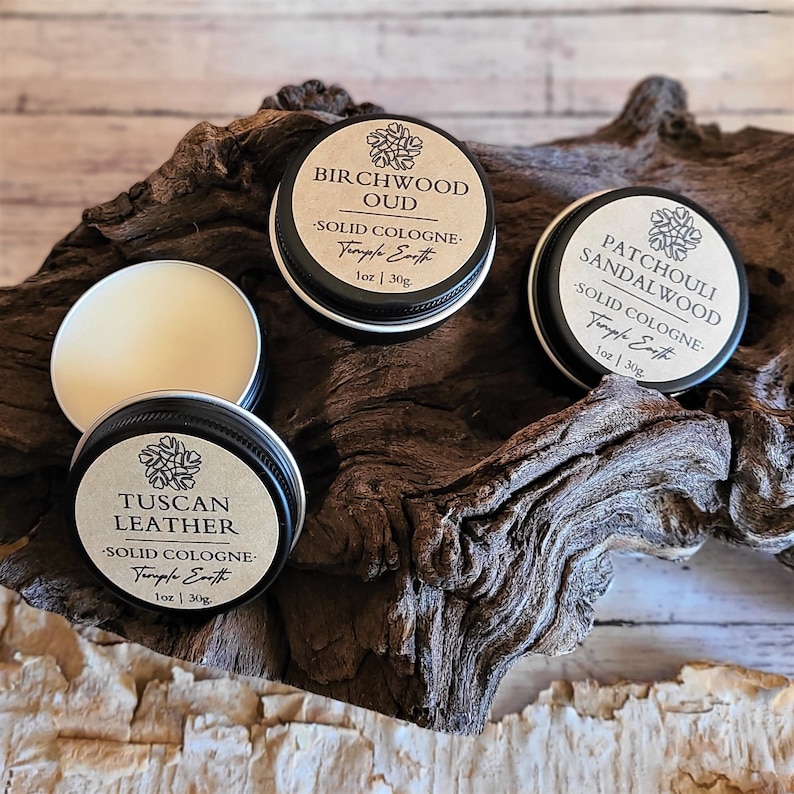 Pu&ograve; includere: Tre piccole lattine rotonde di metallo con coperchi neri ed etichette di carta marrone. Le etichette riportano i nomi di diverse fragranze: Oud di betulla, Sandalo di patchouli e Cuoio toscano. Ogni lattina contiene una colonia solida ed &egrave; etichettata "Temple Earth" con la dimensione "1 oz | 30g".