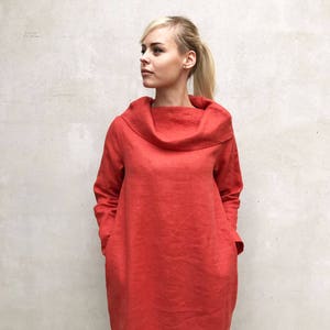 May include: A long-sleeved, red linen dress with a cowl neck and pockets.