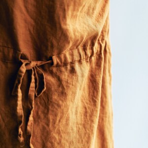 May include: A brown linen dress with a drawstring waist.
