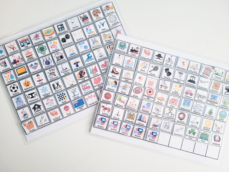 May include: Two white laminated sheets with colorful squares containing icons and text. The squares are arranged in a grid pattern. The icons represent various activities, holidays, and events. The text includes the names of the activities, holidays, and events.