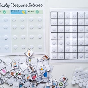 K&ouml;nnte beinhalten: Ein wei&szlig;es Brett mit dem Titel "Nathan's Daily Responsibilities", das in Morgen- und Abendabschnitte unterteilt ist. Jeder Abschnitt hat eine Spalte f&uuml;r Aufgaben und eine Spalte zum Markieren von Aufgaben als erledigt. Auf dem Brett befinden sich wei&szlig;e Kreise zum Anbringen von Aufklebern. Unter dem Brett liegt ein Stapel kleiner quadratischer Aufkleber mit verschiedenen Bildern. Es gibt ein separates Blatt Papier mit einem Raster aus wei&szlig;en Kreisen.