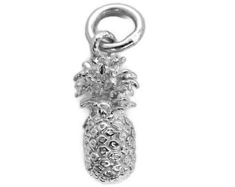 May include: A silver charm in the shape of a pineapple. The pineapple has a detailed design with a textured surface.