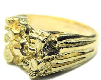 May include: A gold nugget ring with a textured band. The ring is made of solid gold and has a chunky, irregular shape.