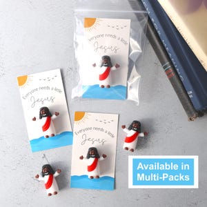 May include: Three small cards with a blue and white background and a sun graphic. Each card has the text "Everyone needs a little Jesus" and a small figurine of Jesus standing on water. The text "Available in Multi-Packs" is at the bottom of the image.