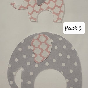 May include: A pack of three felt elephant appliques. One elephant is pink with a white floral pattern, and the other is gray with white polka dots. The text "Pack 3" is written on a white background.