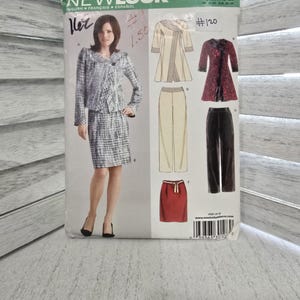Pode incluir: Molde de costura New Look 6672, tamanho A 10-22, com ilustrações de um casaco, saia e calças. O envelope exibe um modelo vestindo um conjunto de casaco e saia xadrez, com desenhos lineares adicionais das peças em várias cores.