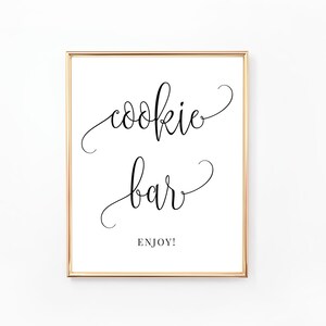 May include: A printable sign with a gold frame that says "cookie bar" in cursive script with the word "enjoy" underneath.