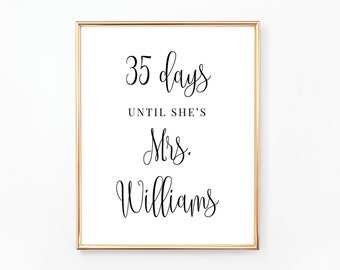May include: A gold framed sign with the text "35 days until she's Mrs. Williams" in black cursive font.