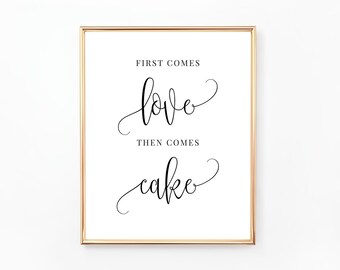 May include: A white sign with a gold frame and black calligraphy that reads "First comes love, then comes cake".