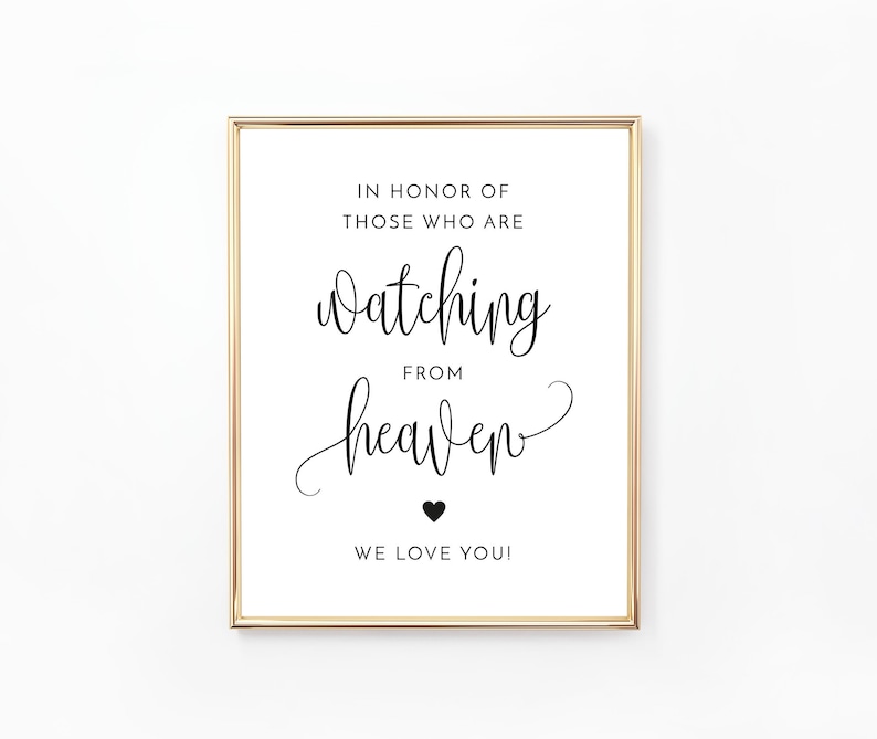 May include: A white sign with a gold frame, featuring the text "In honor of those who are watching from heaven. We love you!" with a small black heart.
