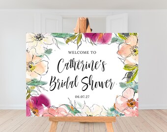 Könnte beinhalten: Ein weißes Willkommens-Schild mit einem floralen Rand und dem Text "Willkommen zu Catherine's Bridal Shower. 06.07.27"