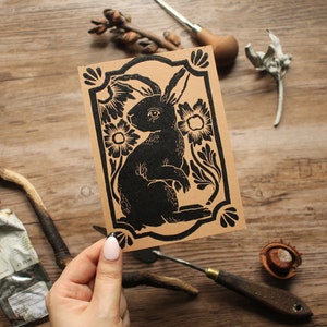 Handgemaakte linosnede kunstdruk konijn / konijn zwart op bruin - briefkaartformaat