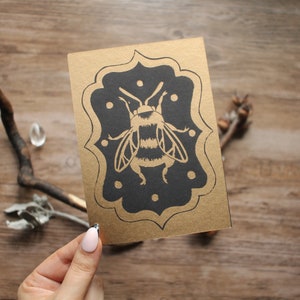 Handgemaakte linosnede kunstdruk "The Bee" goud op zwart - briefkaartformaat
