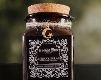 May include: A dark brown glass jar candle with a cork lid, tied with twine and a gold charm. The label reads "Midnight Muse" and "Sherlock Holmes" with scent notes. A wooden wick soy blend candle.