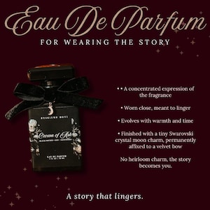 Puede incluir: Botella de perfume negra con un lazo de terciopelo negro y un dije de luna de cristal Swarovski. La botella est&aacute; etiquetada como "Crown of Ash" y "Eau De Parfum". El texto de la imagen dice "For wearing the story" y "A story that lingers."