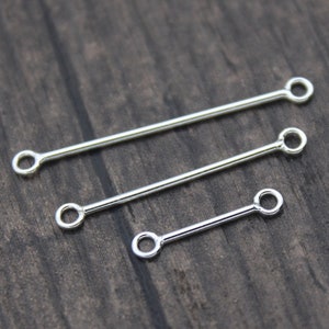 May include: Three silver jump rings of different sizes, each with a straight bar and two circular loops at the ends.