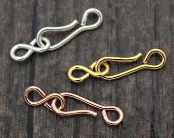 May include: Three metal clasps in silver, gold, and rose gold. Each clasp has a hook and loop design.