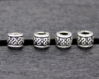 May include: Four silver-toned metal beads with an intricate design. The beads are round and have a smooth surface.