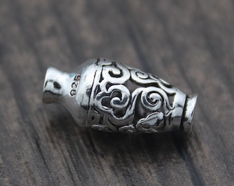 Könnte beinhalten: Silberner Anhänger in Form einer Vase mit aufwendigen floralen Designs. Der Anhänger ist an der Seite mit der Nummer "925" gekennzeichnet.