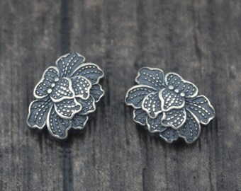 Puede incluir: Un par de pendientes de plata con un diseño floral. Los pendientes están hechos de plata de ley y tienen un diseño delicado e intrincado.