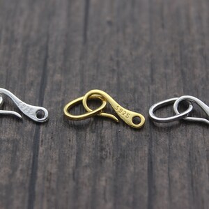 May include: Three silver-toned metal clasps with a hook design. Each clasp has the text "S925" engraved on it.