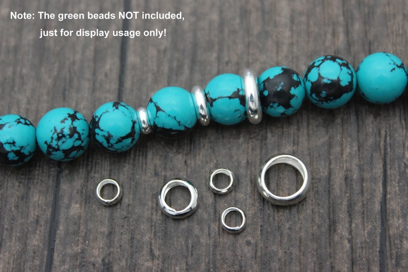 May include: A turquoise and black gemstone bracelet with silver spacer beads. The bracelet is shown with five silver jump rings of varying sizes.