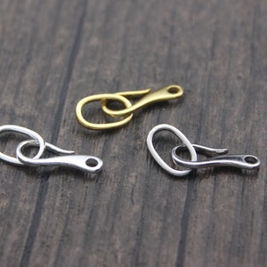 May include: Three metal clasps in different finishes: gold, silver, and nickel. Each clasp has a hook and loop design.