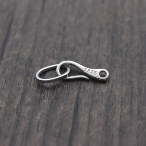 May include: Silver-toned lobster clasp with a ring, marked "S925" on the clasp.