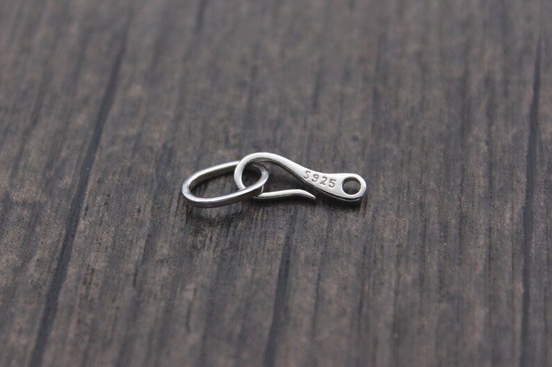 May include: Silver-toned lobster clasp with a ring, marked "S925" on the clasp.