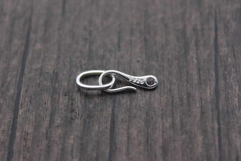 May include: Silver-toned metal clasp with a hook and loop closure. The clasp is marked with the number "925" indicating it is made of sterling silver.