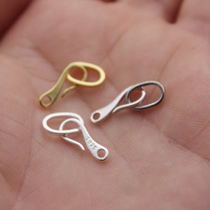 May include: Two silver and one gold lobster claw clasps. The silver clasps are stamped with 925.
