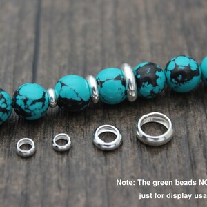 May include: Five silver jump rings of different sizes, with a turquoise and black bead bracelet in the background. Note: The green beads NOT included, just for display usage only!
