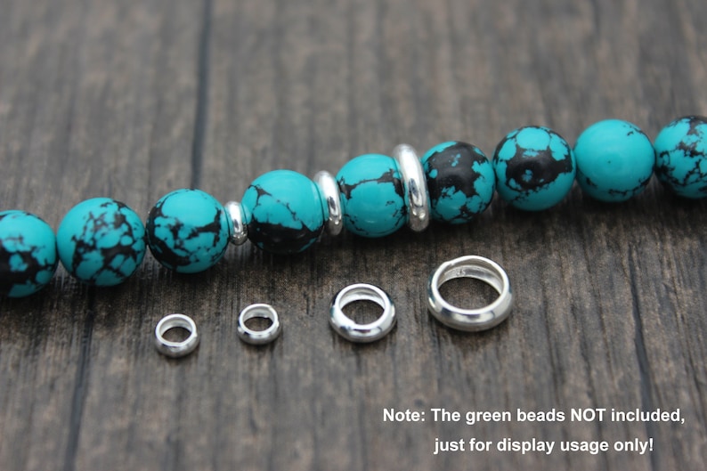 May include: Five silver jump rings of different sizes, with a turquoise and black bead bracelet in the background. Note: The green beads NOT included, just for display usage only!