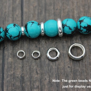May include: Silver jump rings in various sizes, perfect for jewelry making. The rings are shown next to a turquoise beaded bracelet, but the beads are not included.