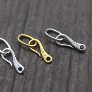 May include: Three silver and gold lobster clasps, each inscribed with "S925".