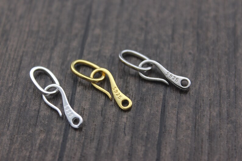 May include: Three silver and gold lobster clasps, each inscribed with "S925".