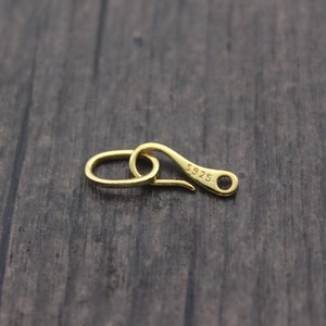 May include: Gold-toned metal clasp with a hook and a loop. The clasp is marked with the text "S925".